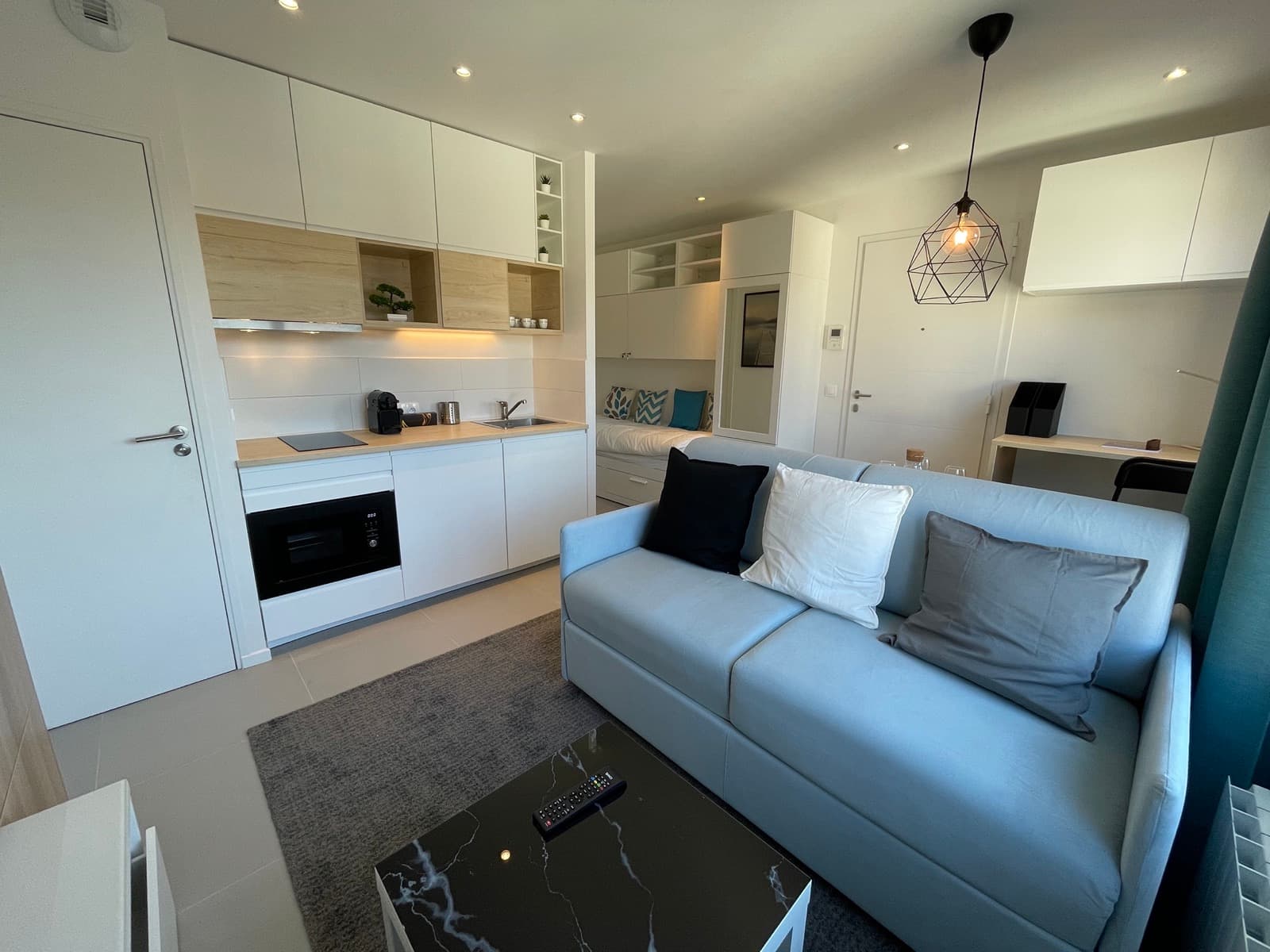 Salon avec canapé-lit et cuisine équipée, Blue Cocoon — Studio 27m² à Villejust (Essonne, Île-de-France)